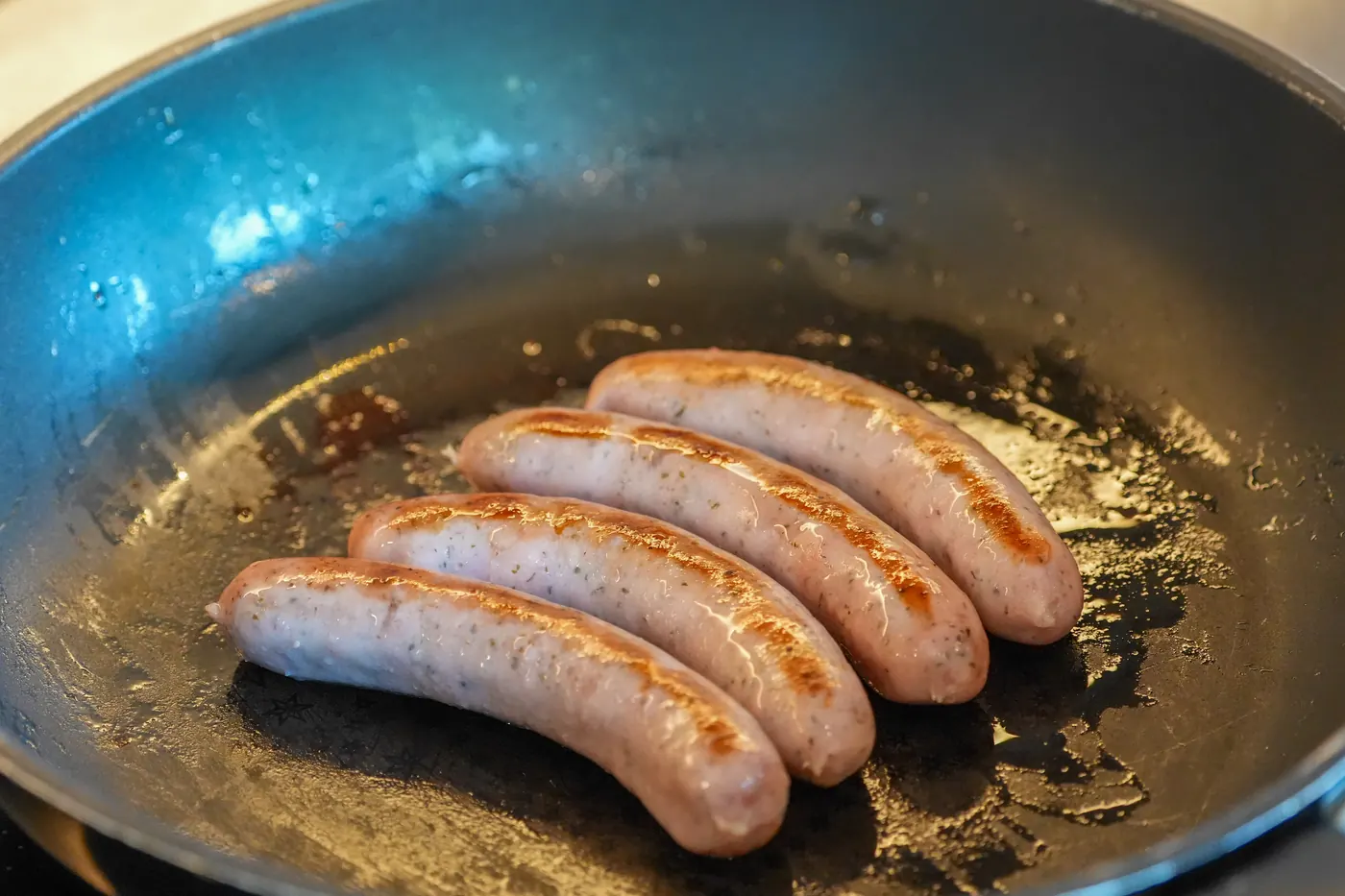 フライパンでソーセージを焼いているところ